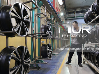 A worker is producing a wheel hub at a workshop of an automobile wheel manufacturer in Binzhou, China, on May 27, 2024. (