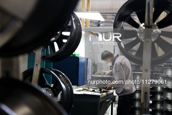 A worker is producing a wheel hub at a workshop of an automobile wheel manufacturer in Binzhou, China, on May 27, 2024. 