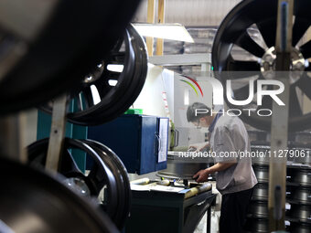 A worker is producing a wheel hub at a workshop of an automobile wheel manufacturer in Binzhou, China, on May 27, 2024. (