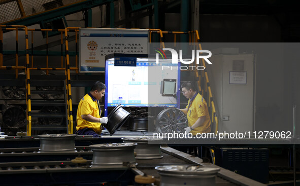 Workers are producing wheels at a workshop of an automobile wheel manufacturer in Binzhou, China, on May 27, 2024. 