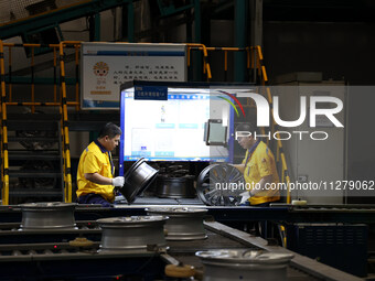 Workers are producing wheels at a workshop of an automobile wheel manufacturer in Binzhou, China, on May 27, 2024. (