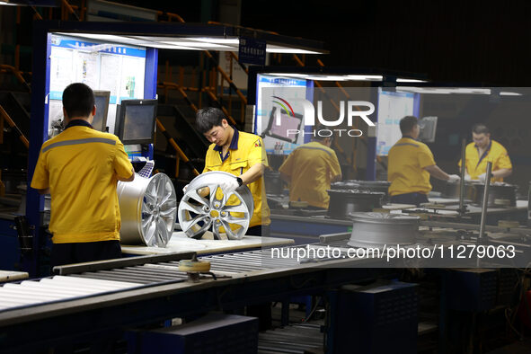 Workers are producing wheels at a workshop of an automobile wheel manufacturer in Binzhou, China, on May 27, 2024. 