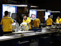 Workers are producing wheels at a workshop of an automobile wheel manufacturer in Binzhou, China, on May 27, 2024. (