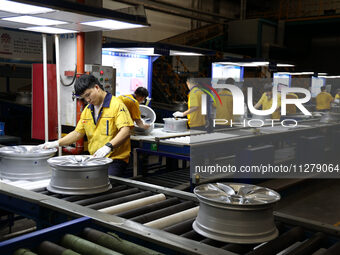 Workers are producing wheels at a workshop of an automobile wheel manufacturer in Binzhou, China, on May 27, 2024. (