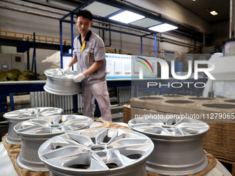 A worker is producing a wheel hub at a workshop of an automobile wheel manufacturer in Binzhou, China, on May 27, 2024. (