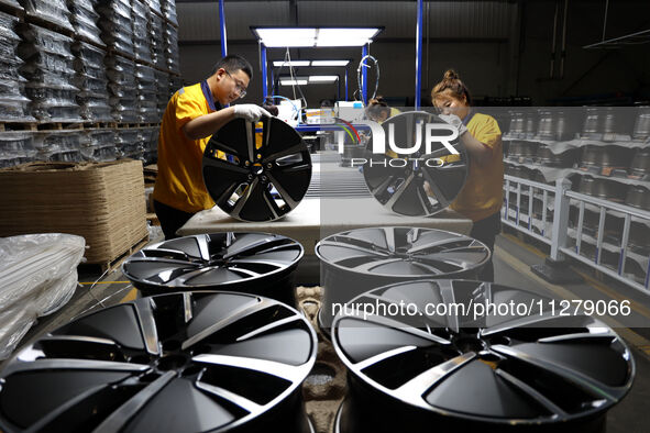 Workers are producing wheels at a workshop of an automobile wheel manufacturer in Binzhou, China, on May 27, 2024. 