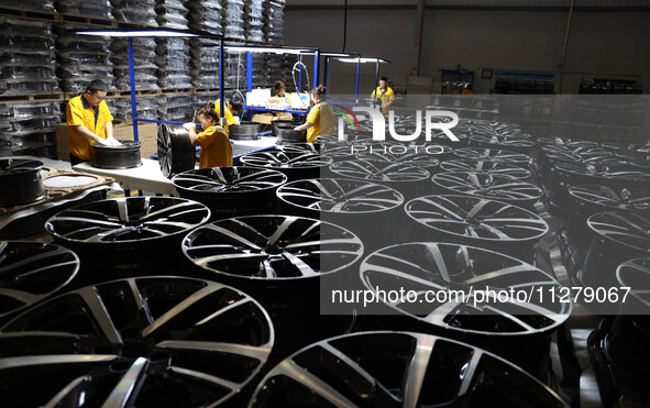 Workers are producing wheels at a workshop of an automobile wheel manufacturer in Binzhou, China, on May 27, 2024. 