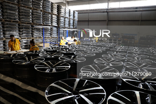 Workers are producing wheels at a workshop of an automobile wheel manufacturer in Binzhou, China, on May 27, 2024. 