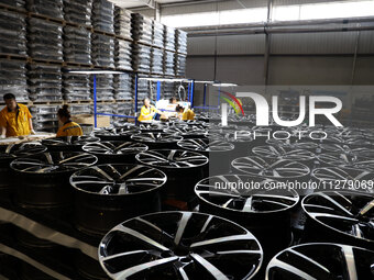 Workers are producing wheels at a workshop of an automobile wheel manufacturer in Binzhou, China, on May 27, 2024. (