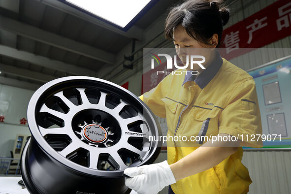 A worker is producing a wheel hub at a workshop of an automobile wheel manufacturer in Binzhou, China, on May 27, 2024. 