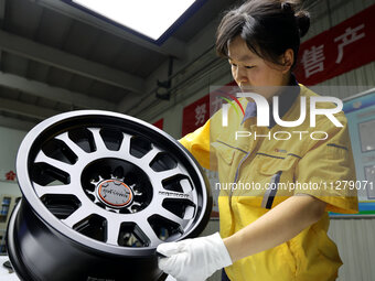 A worker is producing a wheel hub at a workshop of an automobile wheel manufacturer in Binzhou, China, on May 27, 2024. (