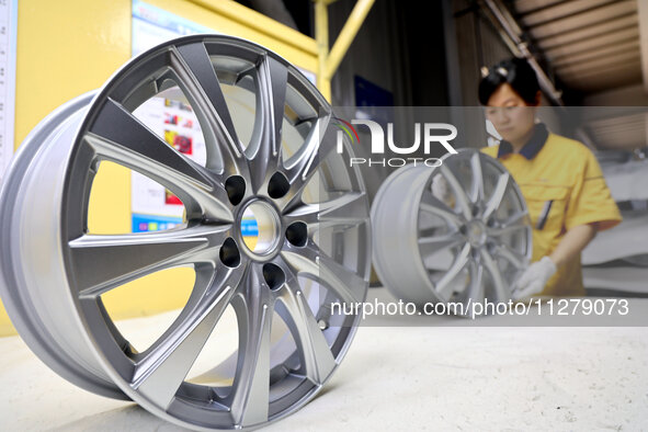 A worker is producing a wheel hub at a workshop of an automobile wheel manufacturer in Binzhou, China, on May 27, 2024. 