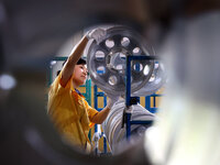 A worker is producing a wheel hub at a workshop of an automobile wheel manufacturer in Binzhou, China, on May 27, 2024. (