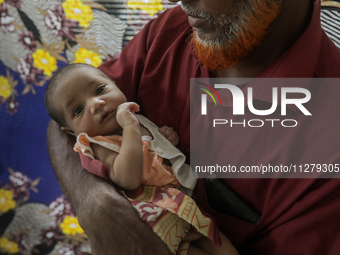 An infant baby is being seen in a cyclone shelter center as Cyclone Remal is landing in Satkhura, Bangladesh, on May 27, 2024. (