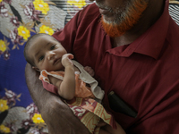 An infant baby is being seen in a cyclone shelter center as Cyclone Remal is landing in Satkhura, Bangladesh, on May 27, 2024. (