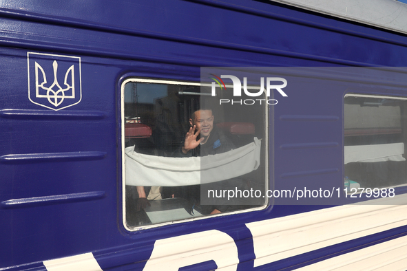 A boy is waving goodbye from a sleeper car as families with children evacuated from the frontline areas of Kharkiv region are going on vacat...