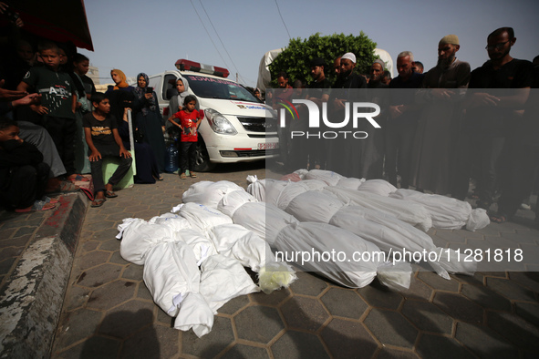 People are mourning by the bodies of relatives killed after Israeli bombardment hit a family home in Nuseirat, at the Al-Aqsa Martyrs Hospit...