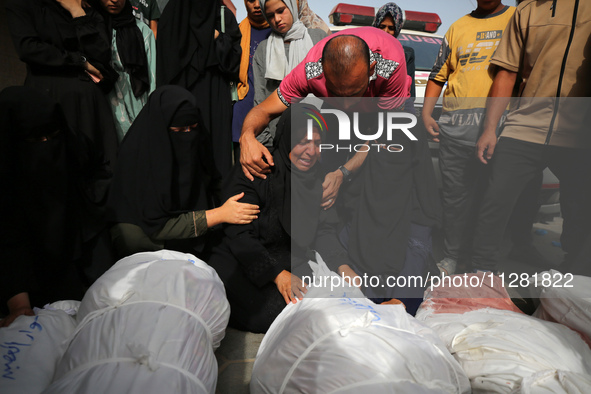 People are mourning by the bodies of relatives killed after Israeli bombardment hit a family home in Nuseirat, at the Al-Aqsa Martyrs Hospit...