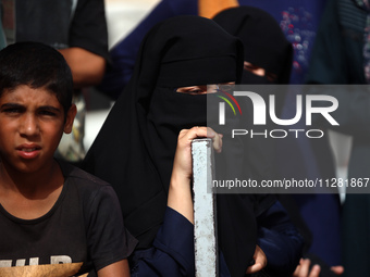 Palestinians are gathering at the site of an Israeli strike on a camp for internally displaced people in Rafah, on May 27, 2024, amid ongoin...