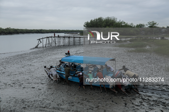 Villagers are pushing a speedboat through mud to rescue wildlife trapped amidst Cyclone Remal in Satkhira, Bangladesh, on May 28, 2024. 