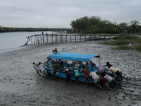 Villagers are pushing a speedboat through mud to rescue wildlife trapped amidst Cyclone Remal in Satkhira, Bangladesh, on May 28, 2024. (