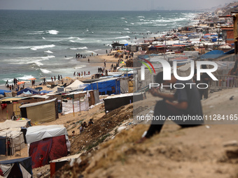 A general view is showing tents housing internally displaced Palestinians crowding the beach and the Mediterranean shoreline in Deir el-Bala...