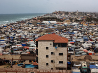 A general view is showing tents housing internally displaced Palestinians crowding the beach and the Mediterranean shoreline in Deir el-Bala...