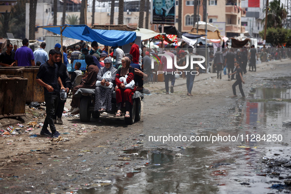 Displaced Palestinians are walking near sewage water in Deir el-Balah in the central Gaza Strip on May 28, 2024, amid the ongoing conflict b...