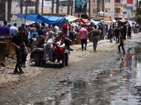 Displaced Palestinians are walking near sewage water in Deir el-Balah in the central Gaza Strip on May 28, 2024, amid the ongoing conflict b...