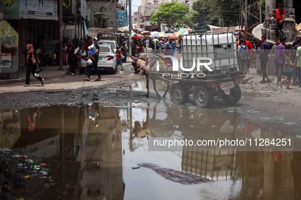 Displaced Palestinians are walking near sewage water in Deir el-Balah in the central Gaza Strip on May 28, 2024, amid the ongoing conflict b...