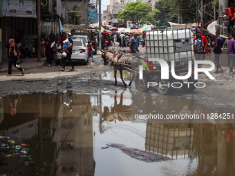 Displaced Palestinians are walking near sewage water in Deir el-Balah in the central Gaza Strip on May 28, 2024, amid the ongoing conflict b...