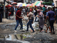 Displaced Palestinians are walking near sewage water in Deir el-Balah in the central Gaza Strip on May 28, 2024, amid the ongoing conflict b...