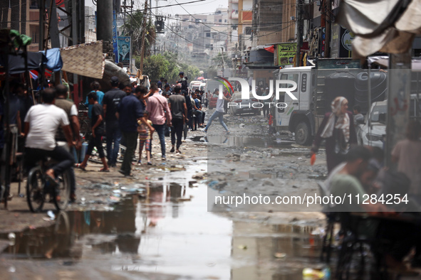 Displaced Palestinians are walking near sewage water in Deir el-Balah in the central Gaza Strip on May 28, 2024, amid the ongoing conflict b...