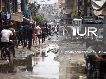 Displaced Palestinians are walking near sewage water in Deir el-Balah in the central Gaza Strip on May 28, 2024, amid the ongoing conflict b...