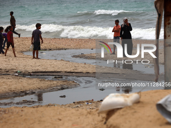 Displaced Palestinians are walking near sewage water in Deir el-Balah in the central Gaza Strip on May 28, 2024, amid the ongoing conflict b...