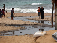 Displaced Palestinians are walking near sewage water in Deir el-Balah in the central Gaza Strip on May 28, 2024, amid the ongoing conflict b...