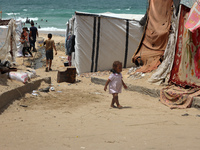 Displaced Palestinians are walking near sewage water in Deir el-Balah in the central Gaza Strip on May 28, 2024, amid the ongoing conflict b...