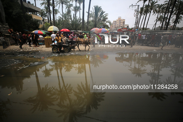 Displaced Palestinians are walking near sewage water in Deir el-Balah in the central Gaza Strip on May 28, 2024, amid the ongoing conflict b...