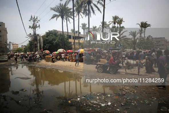 Displaced Palestinians are walking near sewage water in Deir el-Balah in the central Gaza Strip on May 28, 2024, amid the ongoing conflict b...