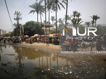 Displaced Palestinians are walking near sewage water in Deir el-Balah in the central Gaza Strip on May 28, 2024, amid the ongoing conflict b...