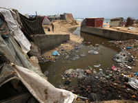 Displaced Palestinians are walking near sewage water in Deir el-Balah in the central Gaza Strip on May 28, 2024, amid the ongoing conflict b...