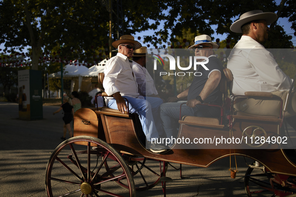 A group of men is riding in a horse-drawn carriage during the festivities of the Corpus Christi in Granada, Spain, on May 28, 2024. The Corp...