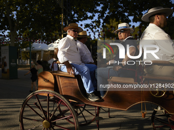 A group of men is riding in a horse-drawn carriage during the festivities of the Corpus Christi in Granada, Spain, on May 28, 2024. The Corp...