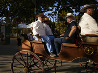 A group of men is riding in a horse-drawn carriage during the festivities of the Corpus Christi in Granada, Spain, on May 28, 2024. The Corp...