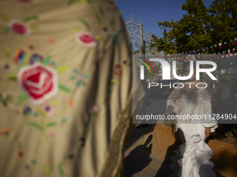 A woman is posing for a photo in a typical flamenco dress during the festivities of the Corpus Christi in Granada, Spain, on May 28, 2024. T...