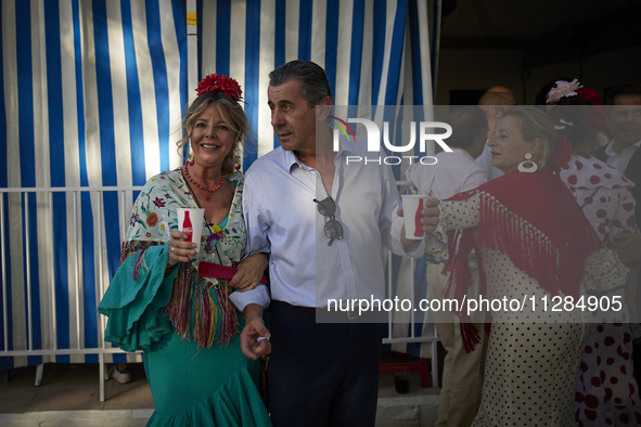 A group of people is drinking in one of the streets next to the ''casetas'' during the festivities of the Corpus Christi in Granada, Spain,...