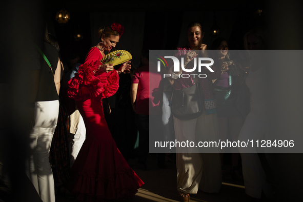 A woman is dressing in a typical flamenco dress and dancing during the festivities of the Corpus Christi in Granada, Spain, on May 28, 2024....