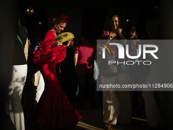 A woman is dressing in a typical flamenco dress and dancing during the festivities of the Corpus Christi in Granada, Spain, on May 28, 2024....