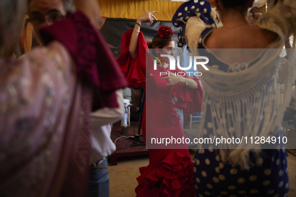 A woman is dressing in a typical flamenco dress and dancing sevillanas during the festivities of the Corpus Christi in Granada, Spain, on Ma...