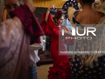 A woman is dressing in a typical flamenco dress and dancing sevillanas during the festivities of the Corpus Christi in Granada, Spain, on Ma...